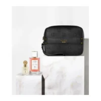 Sac à bandoulière noir et deux flacons de parfum roses et dorés posés sur des socles en marbre